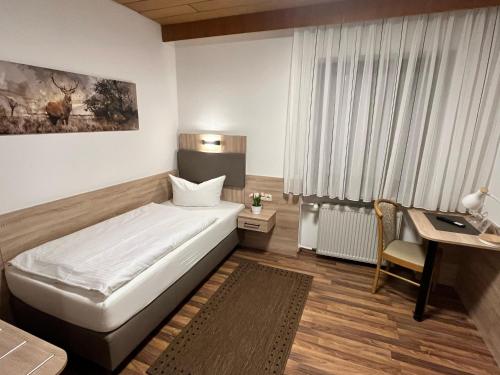 a hotel room with a bed and a desk at Annas Gästehaus in Hallerndorf