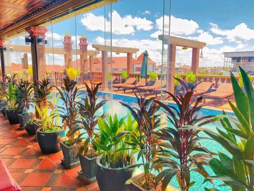 a row of potted plants on a building with a pool at Hello Cambodia Hotel in Phumi Ta Phul