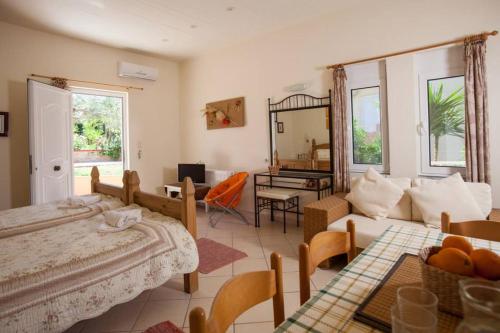 a bedroom with a bed and a living room at Nea Kydonia suites and studios in Daratso