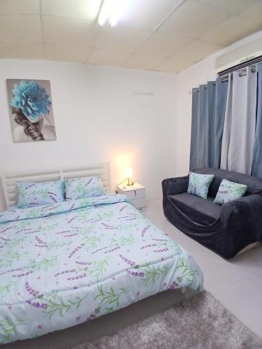 a bedroom with a large bed and a chair at Al Ain Blue in Al Ain