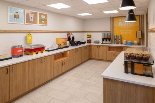 a large kitchen with wooden cabinets and counter tops at Hampton Inn Seattle/Southcenter in Tukwila