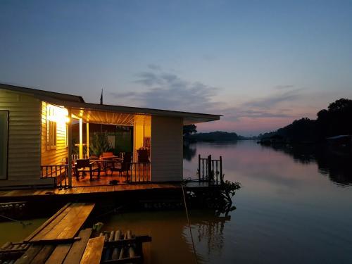 a house on a dock on a body of water at อยู่แพ PaeStay อุทัยธานี in Uthai Thani
