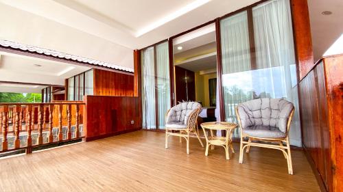 two chairs and a table in a room at Agro Hotel Bintan in Telukbakau