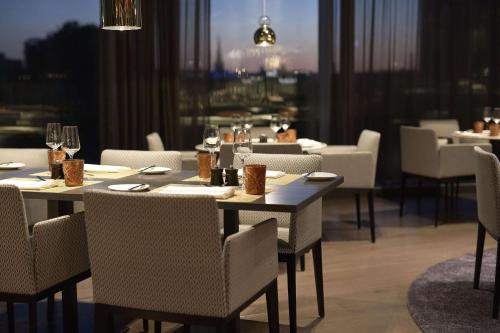 a dining room with tables and chairs in a restaurant at Hilton Tallinn Park in Tallinn