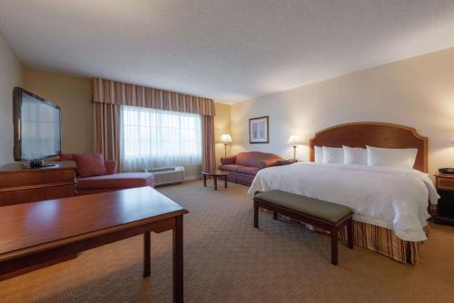 a large hotel room with a bed and a living room at Hampton Inn & Suites - Vicksburg in Vicksburg