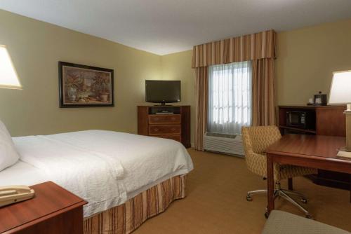 a hotel room with a bed and a desk and a television at Hampton Inn & Suites - Vicksburg in Vicksburg