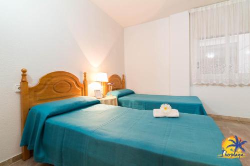 1 Schlafzimmer mit 2 Betten und blauer Bettwäsche in der Unterkunft Center IBERPLAYA in Salou