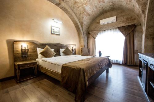 a bedroom with a bed and a large window at Passage Hotel in Baku