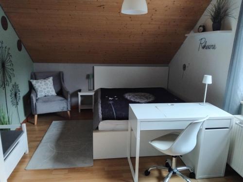 a bedroom with a bed and a desk and a chair at Ferienwohnung Monteurwohnung Pusteblume in Duderstadt