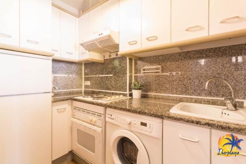 eine Küche mit einer Waschmaschine und einem Waschbecken in der Unterkunft Center IBERPLAYA in Salou