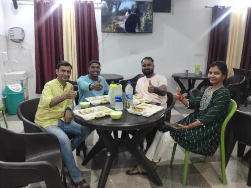 a group of people sitting around a table eating food at Hotel prisha pahal Home stay in Uttarkāshi