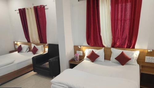 a hotel room with two beds and a chair at Hotel prisha pahal Home stay in Uttarkāshi