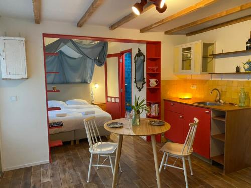 a kitchen and a bedroom with a bed and a table and chairs at charming studio in Amsterdam-Noord in Amsterdam