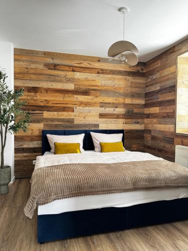 Schlafzimmer mit einer Wand mit Holzakzenten und einem Bett in der Unterkunft Posthaus Kloster Zinna in Jüterbog