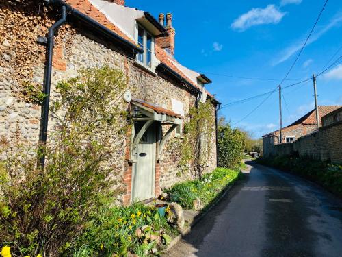 a brick house with a white door on a street at The Hill, Great Walsingham in Little Walsingham
