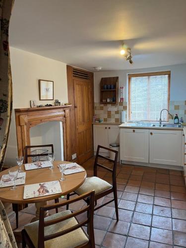 a kitchen with a table and chairs and a sink at The Hill, Great Walsingham in Little Walsingham