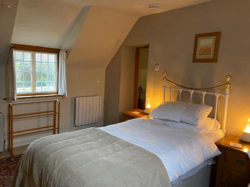 a bedroom with a large bed with white sheets at The Hill, Great Walsingham in Little Walsingham