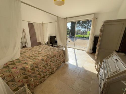 une chambre avec un lit et une grande fenêtre dans l'établissement Appartement Mas de la Mare, à Saint-Andiol