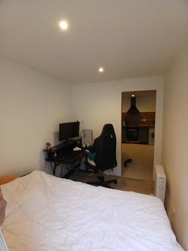 une chambre avec un lit et un bureau avec un ordinateur dans l'établissement Charmant Pied-à-Terre à 150m de la Plage, à Mauguio