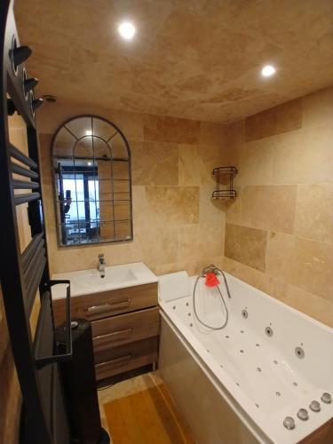 une grande salle de bain avec une baignoire et un lavabo dans l'établissement Charmant Pied-à-Terre à 150m de la Plage, à Mauguio