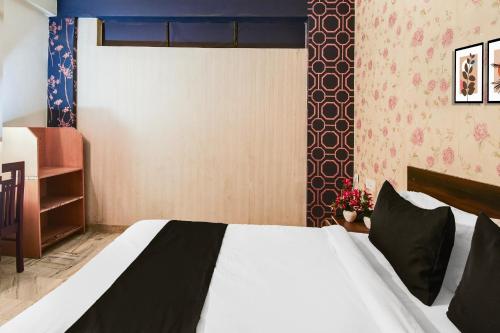 a bedroom with a bed with a black and white comforter at Hotel O Gangashrey in Jaipur