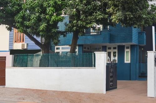 a blue house with a white wall and a fence at Hotel O Gangashrey in Jaipur