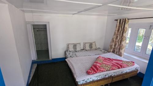 a small room with a bed and a window at Raj guest House in Chitkul