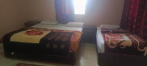 two twin beds in a room with a window at Dana moon hostel in Dana