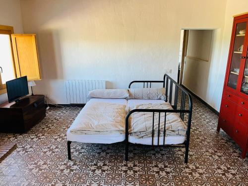 a bedroom with a bed and a dresser and a tv at La Casita Soler The Soler Cottage in Arbós