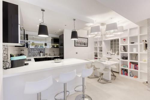 - une cuisine blanche avec des comptoirs et des chaises blancs dans l'établissement Garden flat in Paris 16, à Paris