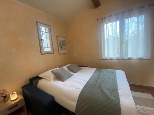 une chambre avec un grand lit avec deux fenêtres dans l'établissement Stunning Provençal Estate, à Callian