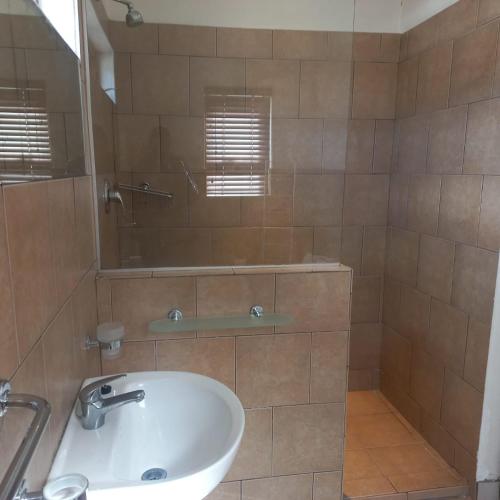 a bathroom with a sink and a mirror at Overnight Lodge in Cape Town