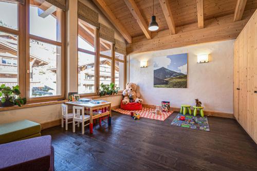 a room with a desk and a table with a teddy bear at Hotel Spitzhorn Superieur in Gstaad