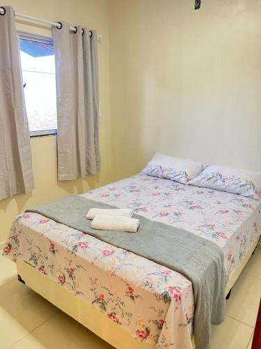 a bedroom with a bed with a blanket and a window at Casa de praia Duplex com Piscina Flecheiras in Trairi