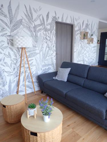 un salon avec un canapé bleu et une table dans l'établissement Ria d'ETEL maison en bois ensoleillée à 150m de la plage, à Plouhinec