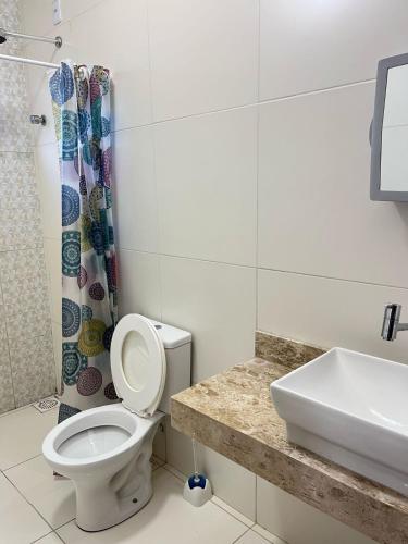 a bathroom with a toilet and a sink at Casa de praia Duplex com Piscina Flecheiras in Trairi