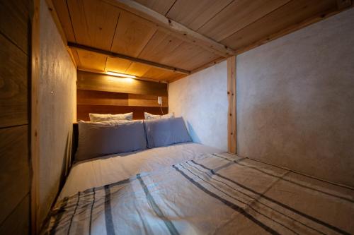a small bed in a small room with at 美ら海水族館まで車4分の一棟貸ヴィラちゅらジャングルリゾート in Motobu