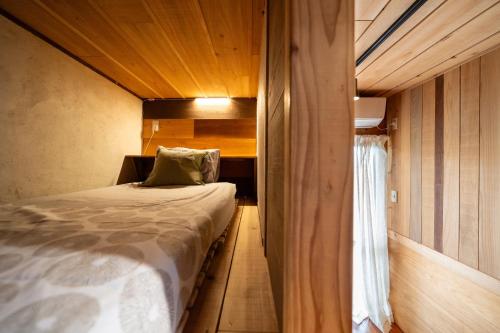 a small room with a bed and a window at 美ら海水族館まで車4分の一棟貸ヴィラちゅらジャングルリゾート in Motobu