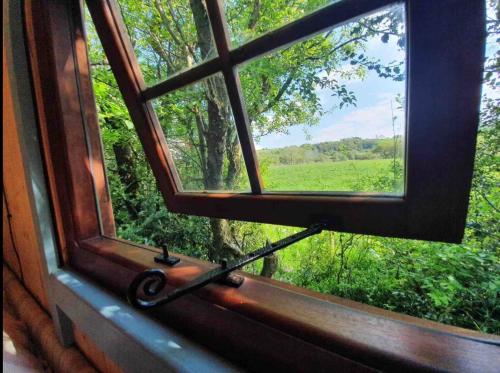 an open window with a view of a field at Hide and Sheep Shepherds Hut in Bradnop