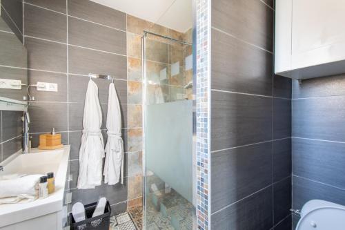 une salle de bain avec une douche avec une porte vitrée dans l'établissement GuestHouse La Costière - logements indépendants - espace piscine jacuzzi, à Lunel