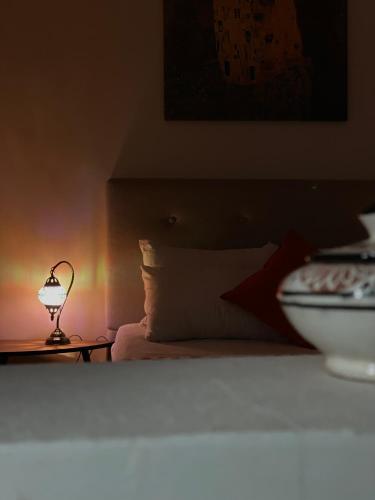 a bedroom with a bed and a lamp on a table at Chic Surf House in Aourir