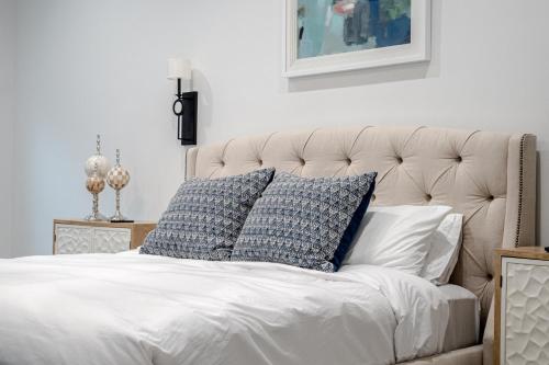 a bed with blue and white pillows on it at Modern Retreat 10 min-Oaklawn BBQ grill Pavillion Kids playground in Hot Springs
