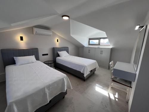 Un dormitorio pequeño con dos camas y una ventana. en Villa Sahra Exclusive DALYAN, en Ortaca