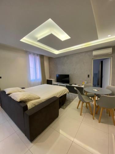 une chambre avec un grand lit et une table et des chaises dans l'établissement Cap d ail 2 pièces proches Monaco et plage, à Saint-Antoine