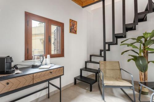 a room with a desk and a staircase with a chair at La carbonaia rooms in Agrigento in Agrigento