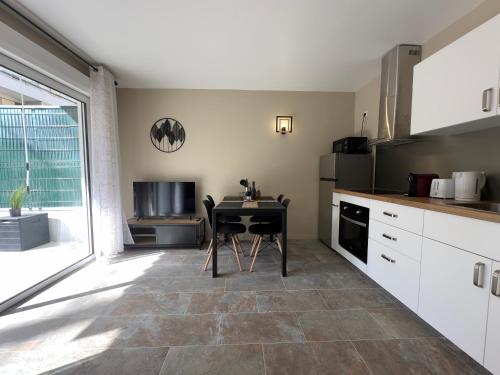 une cuisine avec une table et une chaise. dans l'établissement COSY CASTILLE - Proche de la CROISETTE, à Cannes