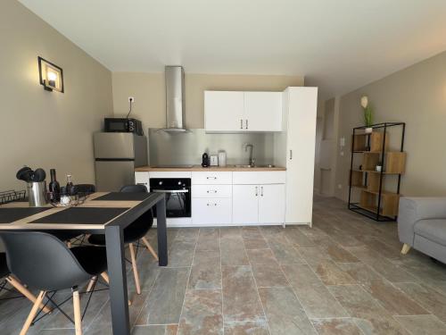une cuisine avec des armoires blanches et une table et des chaises dans l'établissement COSY CASTILLE - Proche de la CROISETTE, à Cannes