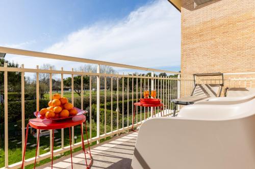 a balcony with two tables with fruit on them at Elegant Seaside Apartment with Pool and Parking in Calambrone