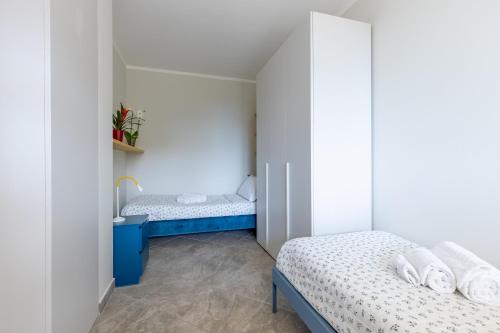 a small room with two beds and a sink at Elegant Seaside Apartment with Pool and Parking in Calambrone