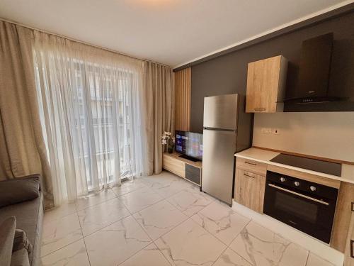 a small kitchen with a refrigerator and a tv at Steps to Sea - Affordable Luxury Living in St. Paul's Bay